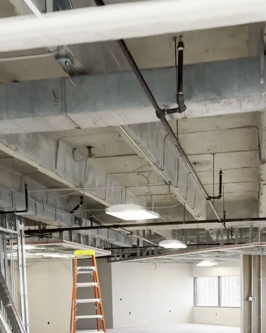 Supply duct mains running across the open floor of a Houston high-rise office build-out